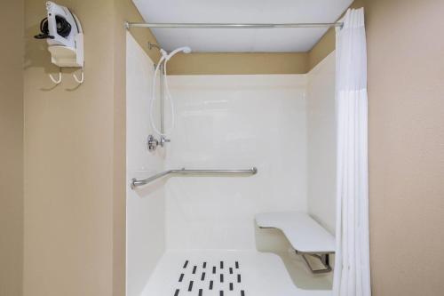 y baño con ducha y banco. en Days Inn & Suites by Wyndham Cuba, en Cuba