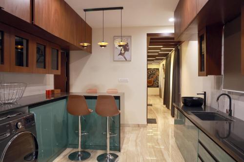 钦奈VLuv Home Stay的厨房配有玻璃台面和2张凳子