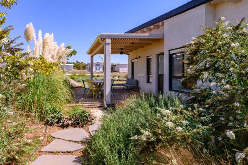 a house with a porch with a table and chairs at צימרים למשפחות, אירוח ~כימים אחדים~ משק אביגור-מקובר in Giv'at Yo'av