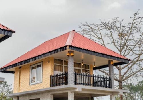 a house with a red roof on top of it at Hotel RaptiRiverview in Khargauli