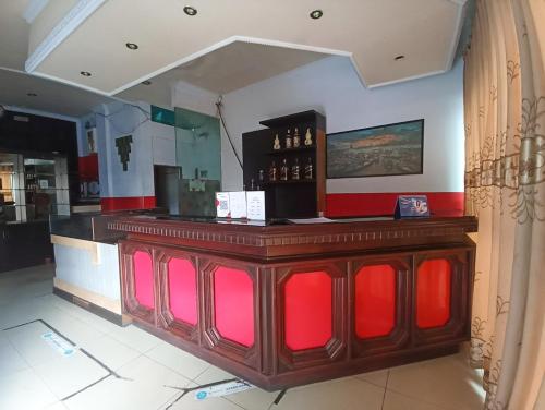 a bar in a restaurant with red and pink at RedDoorz near Sam Ratulangi Manado in Manado