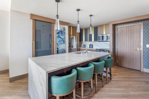 a kitchen with a large island with blue bar stools at Hilton Club Elara Las Vegas in Las Vegas