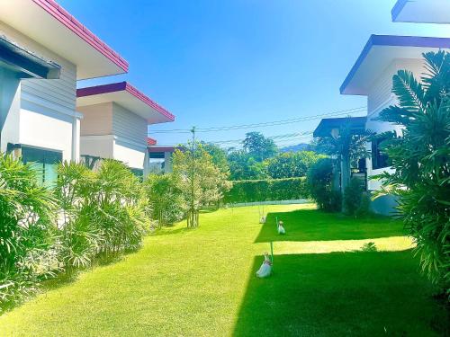 a yard next to a building with trees and a yard at KhaoLak Chill Out in Khao Lak