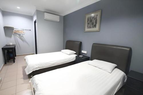 two beds in a room with blue walls at Hotel Station 18 in Kampong Kuala Punti