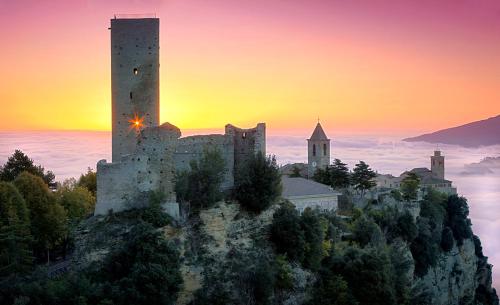 a castle on top of a mountain with a sunset at B&B Marconi in Montefalcone Appennino