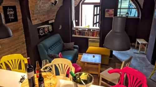 a dining room with a table and colorful chairs at Maksimilian Osijek in Osijek