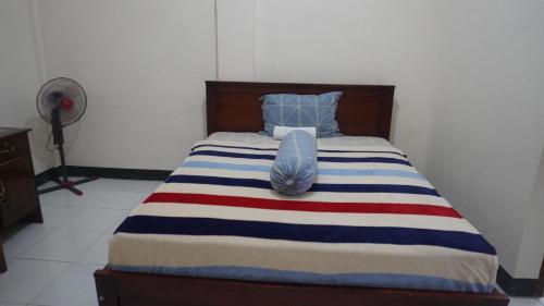 - un lit avec une couverture rouge rayée blanche et bleue dans l'établissement Homestay, à Labuan Bajo