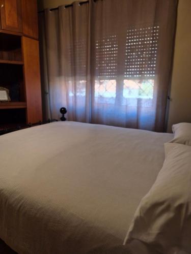 a bedroom with a white bed and a window at Elegantia Domina apartment in the center in Fiumicino