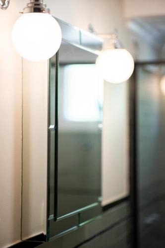 two lights on a mirror in a room at Wilson's Guest House in Wentworth Falls
