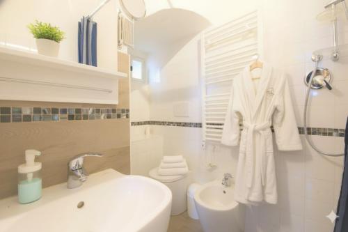 a white bathroom with a sink and a toilet at The Old Ship in Costarainera