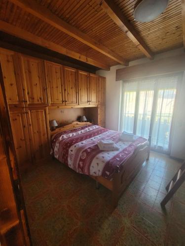 a bedroom with a bed in a room with wooden cabinets at Locazione turistica Cuore d'Altopiano ad Asiago con ricarica per E-Bike in Asiago