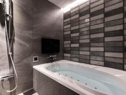 a bath tub in a bathroom with a tv at Y-HOTEL - Vacation STAY 22328v in Hiroshima