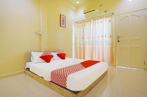 a bedroom with a bed with red pillows on it at Hotel O Wisma Pinggir in Tanjung Pinang 