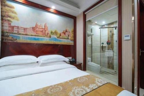 a bedroom with a bed with a painting on the wall at GreenTree Inn Shanghai Waigaoqiao Free Trade Zone Express Hotel in Shanghai