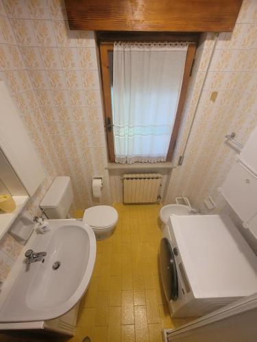 a bathroom with a white sink and a toilet at Locazione turistica Cuore d'Altopiano ad Asiago con ricarica per E-Bike in Asiago