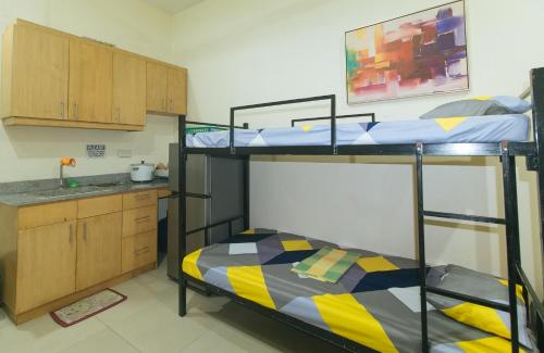 um quarto com 2 beliches e uma cozinha em San Marino JY7 Rentals by RedDoorz em Cebu