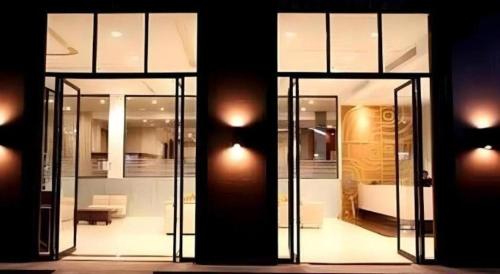 Habitación con puertas de cristal y sala de estar. en The Regent Ubon, en Ban Na Khwai