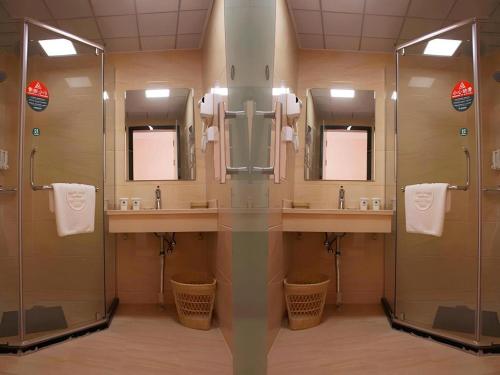een badkamer met 2 wastafels, een douche en spiegels bij GreenTree Inn Shanghai Luojing Express Hotel in Luojing