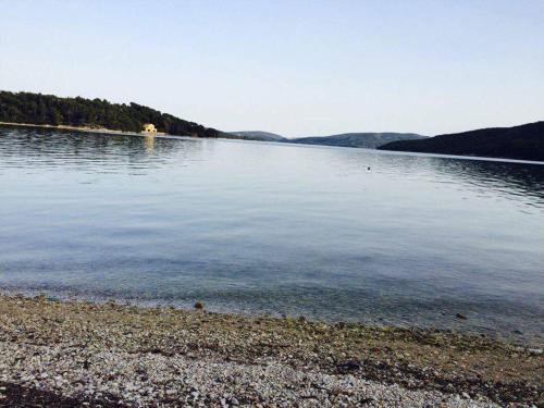 a large body of water with a rocky shore at Akrogiali Studios in Nydri