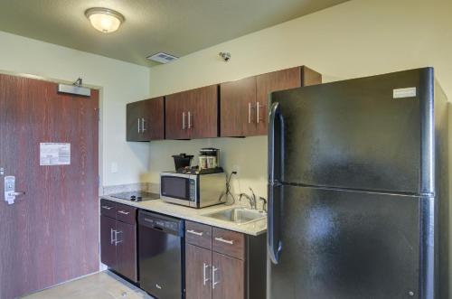 a kitchen with a black refrigerator and a sink at Cobblestone Inn & Suites - Ord in Ord