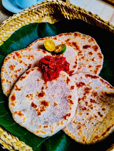 达瓦拉维Maika Safari Lodge的绿色盘子上放着两张涂着红色果酱的煎饼。