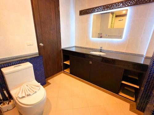 Un baño con inodoro, lavabo y espejo. en Spacious Authentic Thai-style Pool Villa Rawai, en Ban Saiyuan (1)