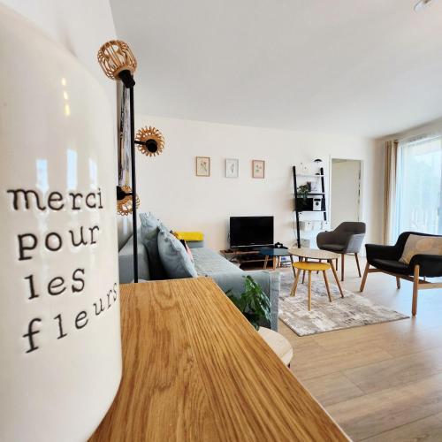 a living room with a couch and a table at Élégant appartement lumineux à Senlis in Senlis