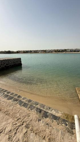 a large body of water with a pier on a beach at فيلا هابي بيتش درة العروس رملي وخاص in Durat Alarous