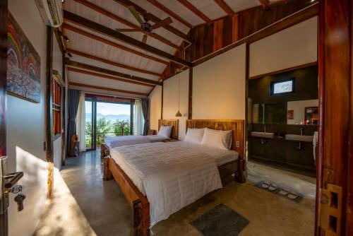 a bedroom with a large bed and a large window at SIM Farmstay in Ha Giang