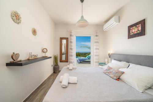 ein Schlafzimmer mit Bett und Blick auf das Meer in der Unterkunft Villa levanda in Mousata