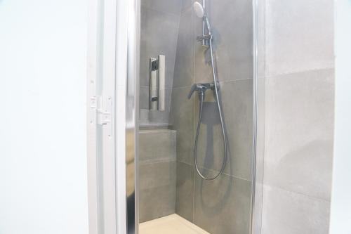 una ducha con cabezal de ducha en un baño en Le Magelan, en Vaires-sur-Marne