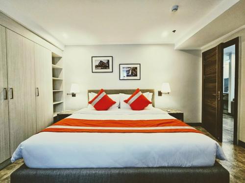 a bedroom with a large bed with red pillows at La Grande Residence 1BR Corner unit Phase 2-710 in Angeles
