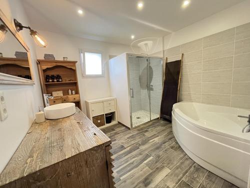 ein Badezimmer mit Badewanne und Glasdusche in der Unterkunft Le Virage du Circuit - Mulsanne in Mulsanne