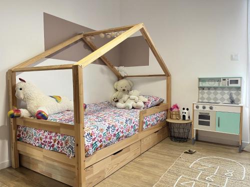 ein Kinderzimmer mit einem Himmelbett mit Stofftieren in der Unterkunft Le Virage du Circuit - Mulsanne in Mulsanne