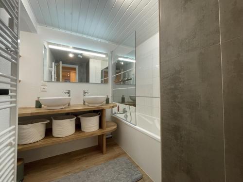 ein Badezimmer mit zwei Waschbecken und einer Badewanne in der Unterkunft Chaleureux appartement Altitude 1500 in Le Lioran