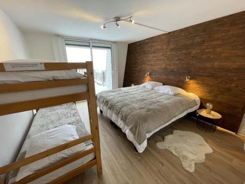 ein Schlafzimmer mit zwei Etagenbetten und einem Fenster in der Unterkunft Chaleureux appartement Altitude 1500 in Le Lioran