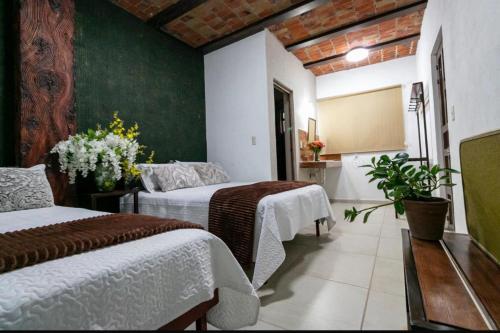 a bedroom with two beds and a green wall at Hotel Casa Zaragoza, San Juan de los Lagos in San Juan de los Lagos