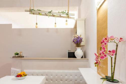 una cocina blanca con flores y una estantería en Olimpo, en Giurdignano