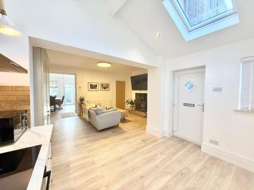 a living room with white walls and a skylight at Tanshelf House - Pontefract Town Centre in Pontefract