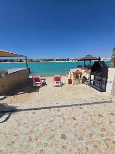 a patio with two chairs and the ocean in the background at فيلا هابي بيتش درة العروس رملي وخاص in Durat Alarous