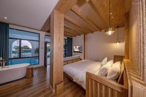 a bedroom with a bed and a bath tub and a bathtub at Fuxian Lake Lanshan Su Ant Nest Homestay in Xujiadu