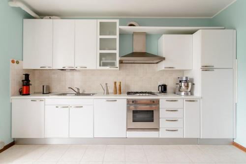 a white kitchen with white cabinets and appliances at Apartment near Treviso in Silea in Silea