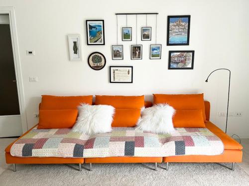 an orange couch in a room with pictures on the wall at Apartment near Treviso in Silea in Silea