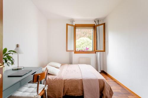 a bedroom with a bed and a desk and a window at Apartment near Treviso in Silea in Silea