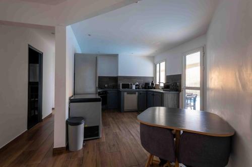 a kitchen with a table and a counter top at villa piscine jacuzzi in Petite Île