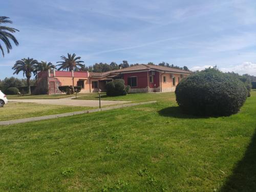 a house in a yard with a green lawn at Le sei palme B&B in Terralba