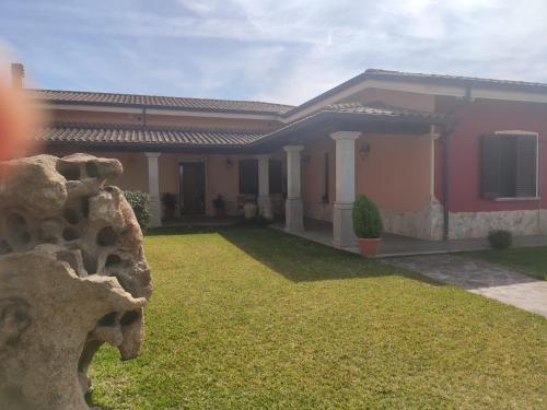 a house with a green lawn in front of it at Le sei palme B&B in Terralba