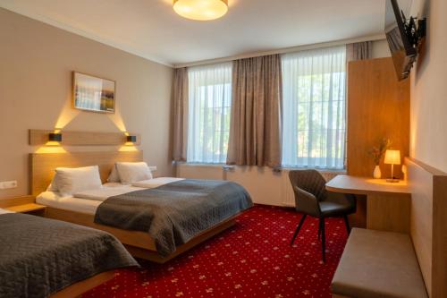 WallseeにあるGasthof Grünlingのベッド2台と机があるホテルの部屋