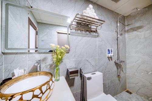 a bathroom with a sink and a toilet and a mirror at Thu Ha Hotel in Uông Bí