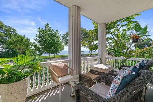 a porch with wicker chairs and a table at Gorgeous Historical Mansion on the Lake Front in Racine